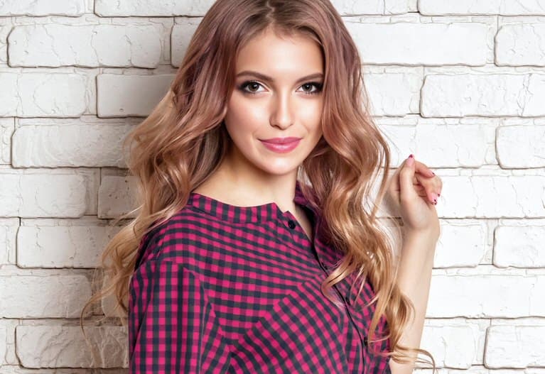 Model posing against white brick wall