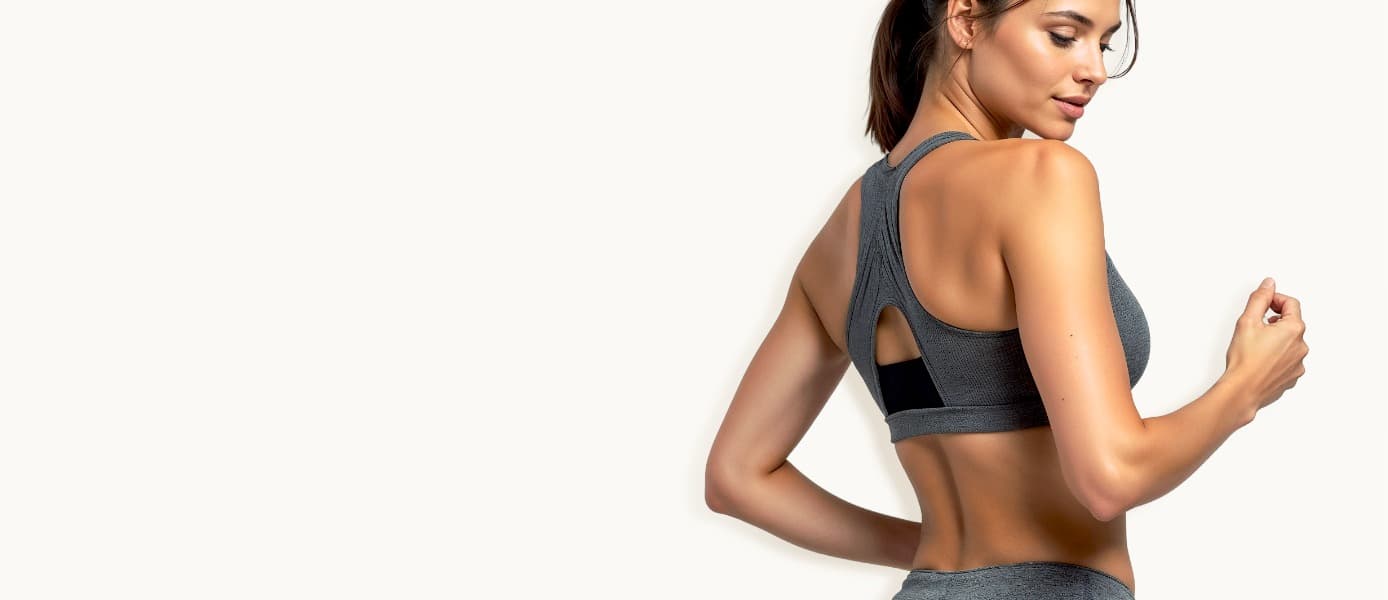 Woman in gray athletic wear turning over her shoulder