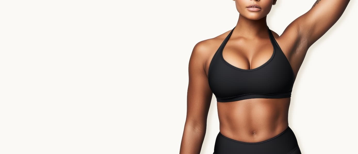 Woman in black athletic wear with one arm raised